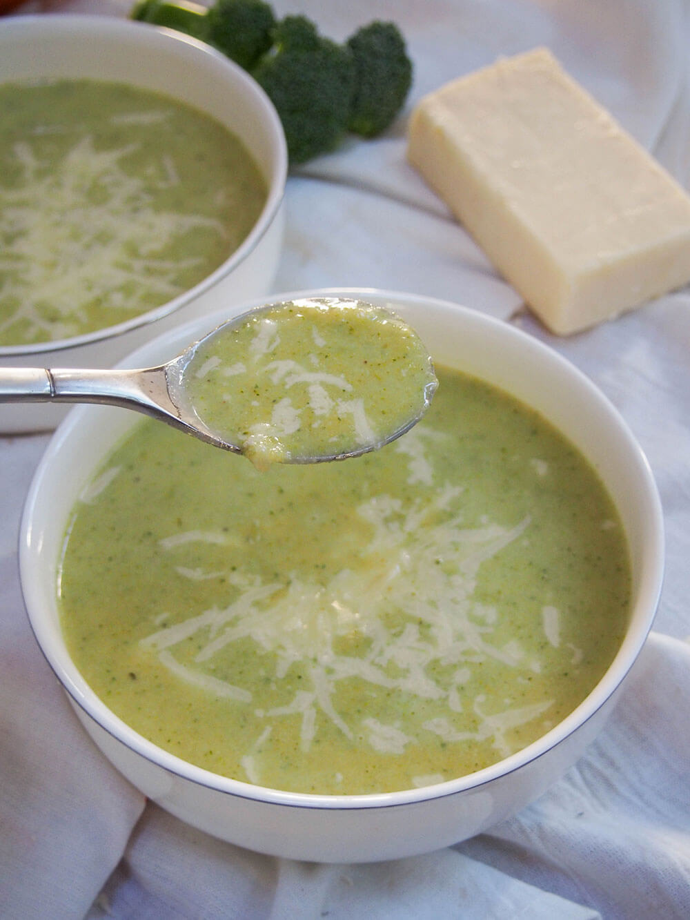 Löffel Kürbis-Brokkoli-Suppe mit Cheddar nehmen