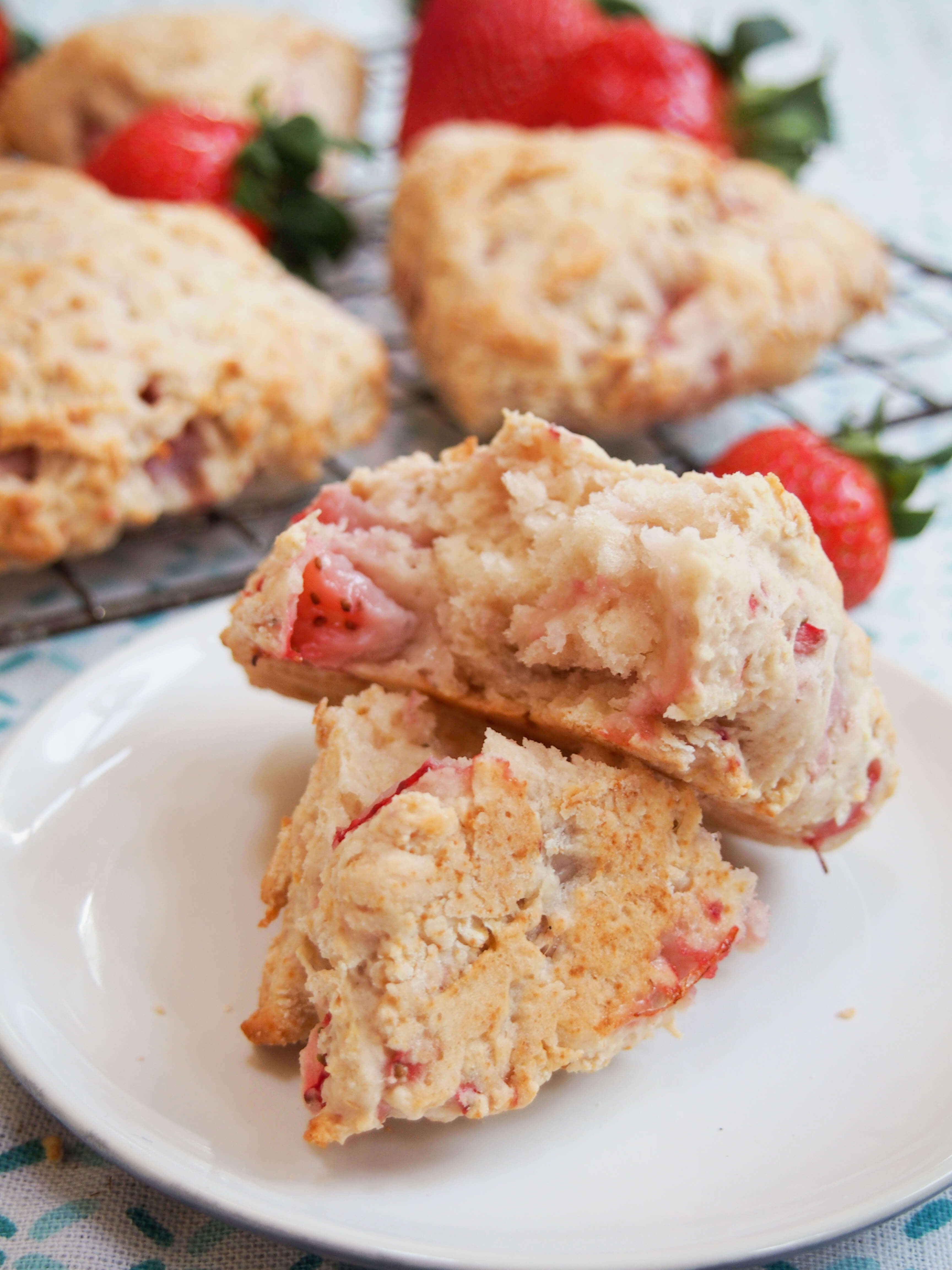 These strawberry scones are made with mascarpone and a double doze of strawberries for a wonderfully soft, fruity mouthful in every bite. Easy to make, they're a wonderful snack. strawberry scone on plate split open