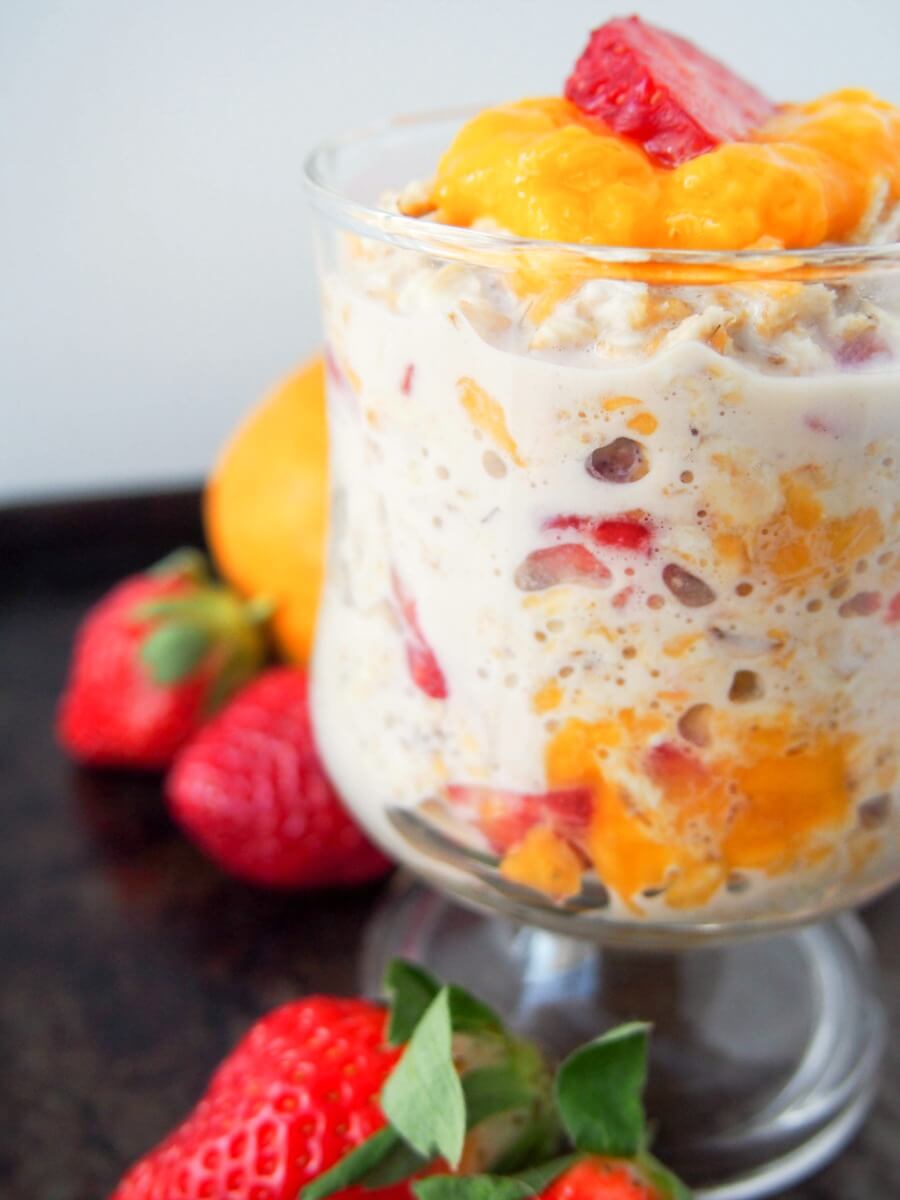 glass of mango and strawberry overnight oats from side