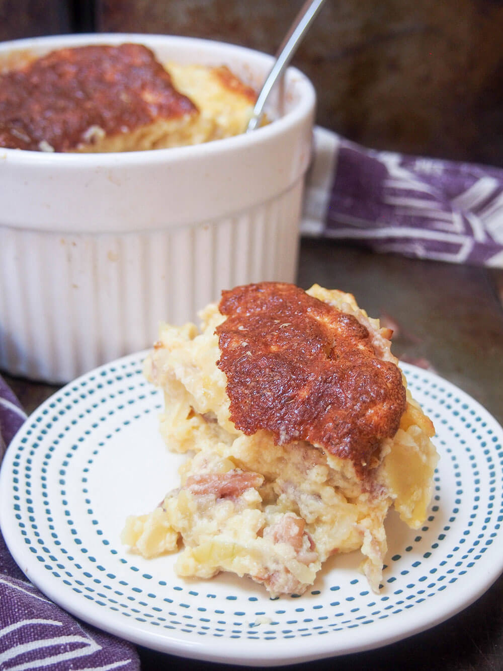 speck potato and cheese souffle with some on plate and dish with rest behind