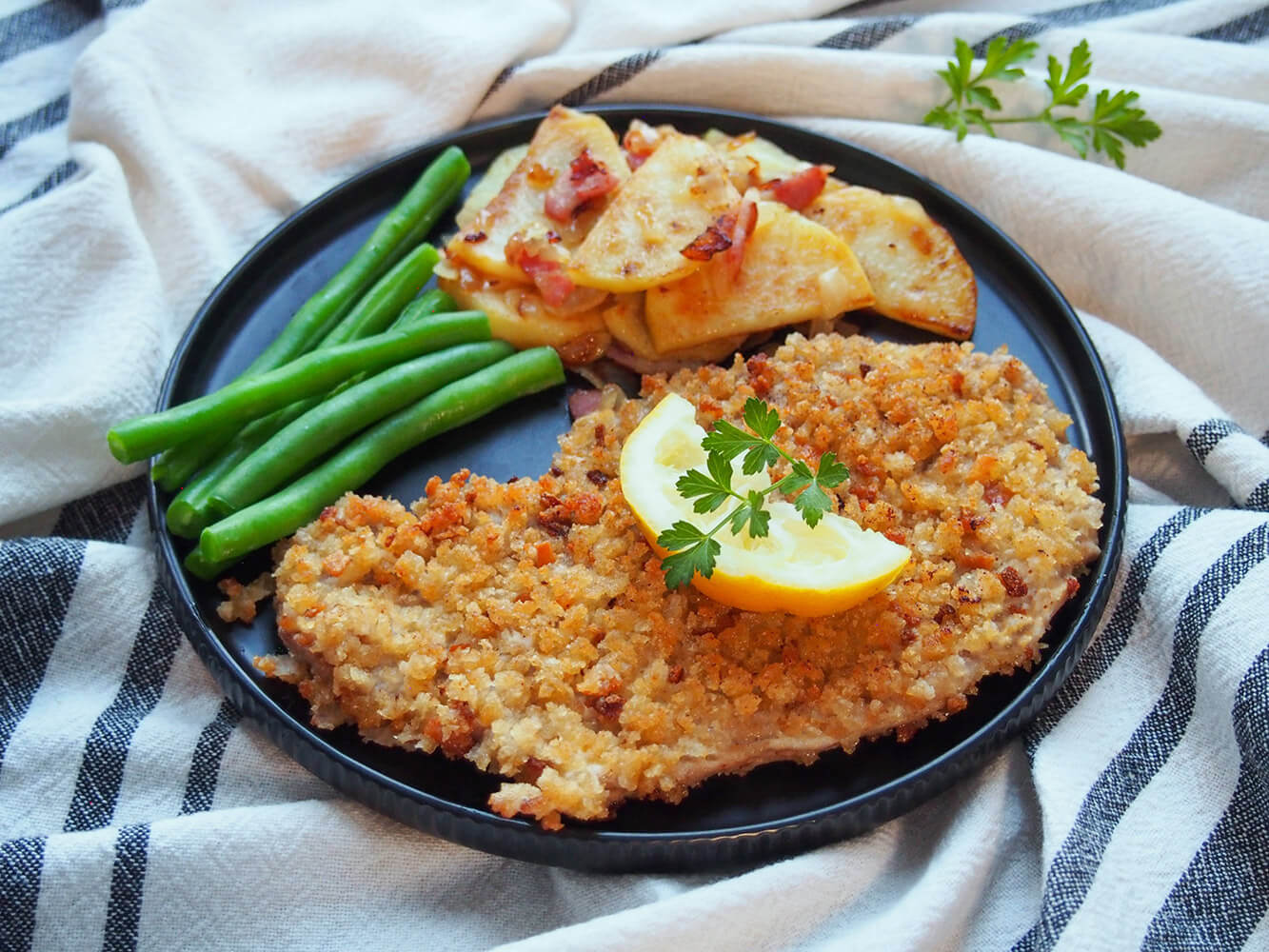Wiener schnitzel on plate with potatoes and beans