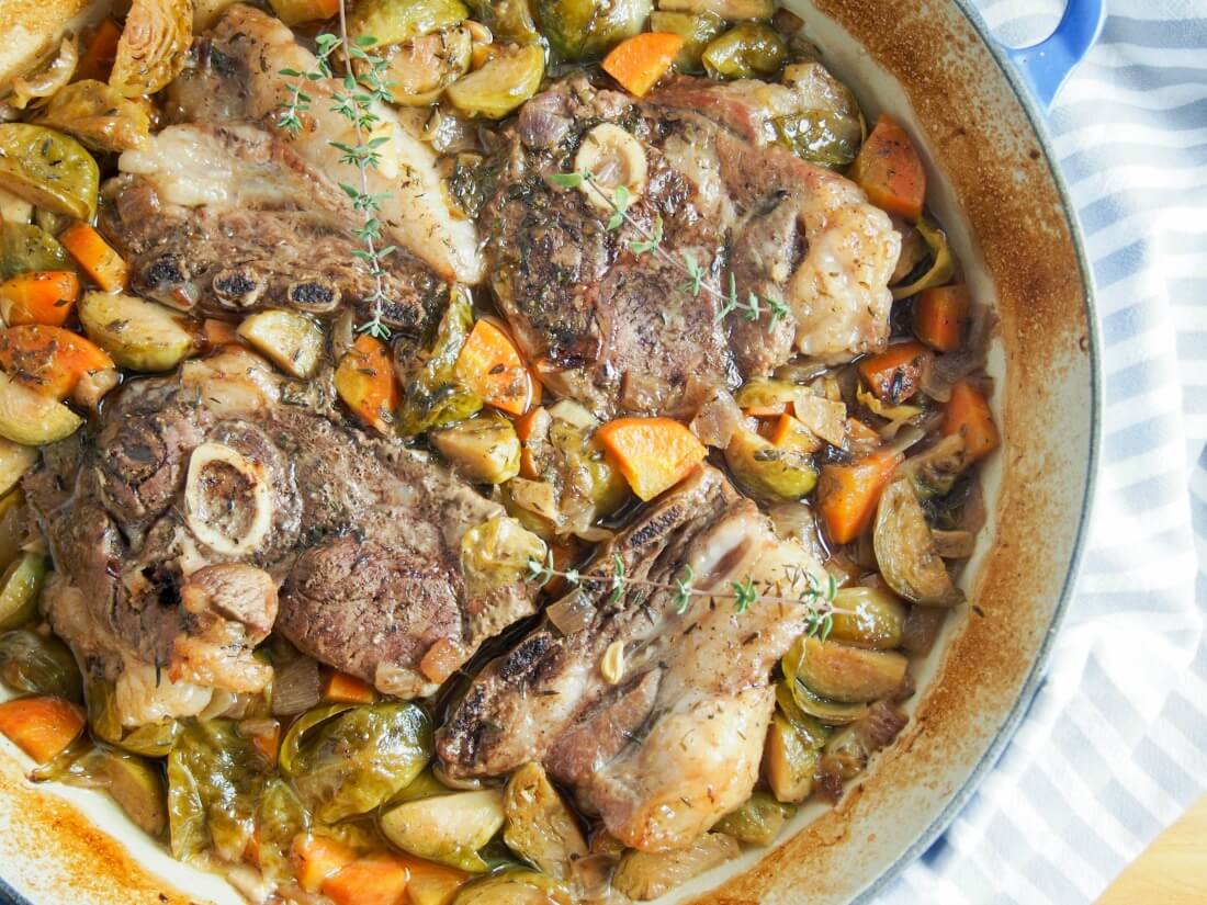 One pot braised lamb shoulder chops and vegetables in dish from overhead