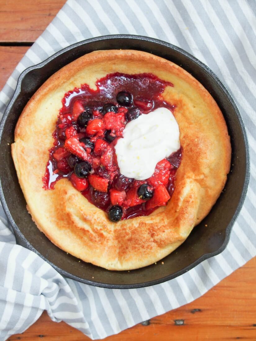 individual Dutch baby pancake with berries and maple yogurt from overhead