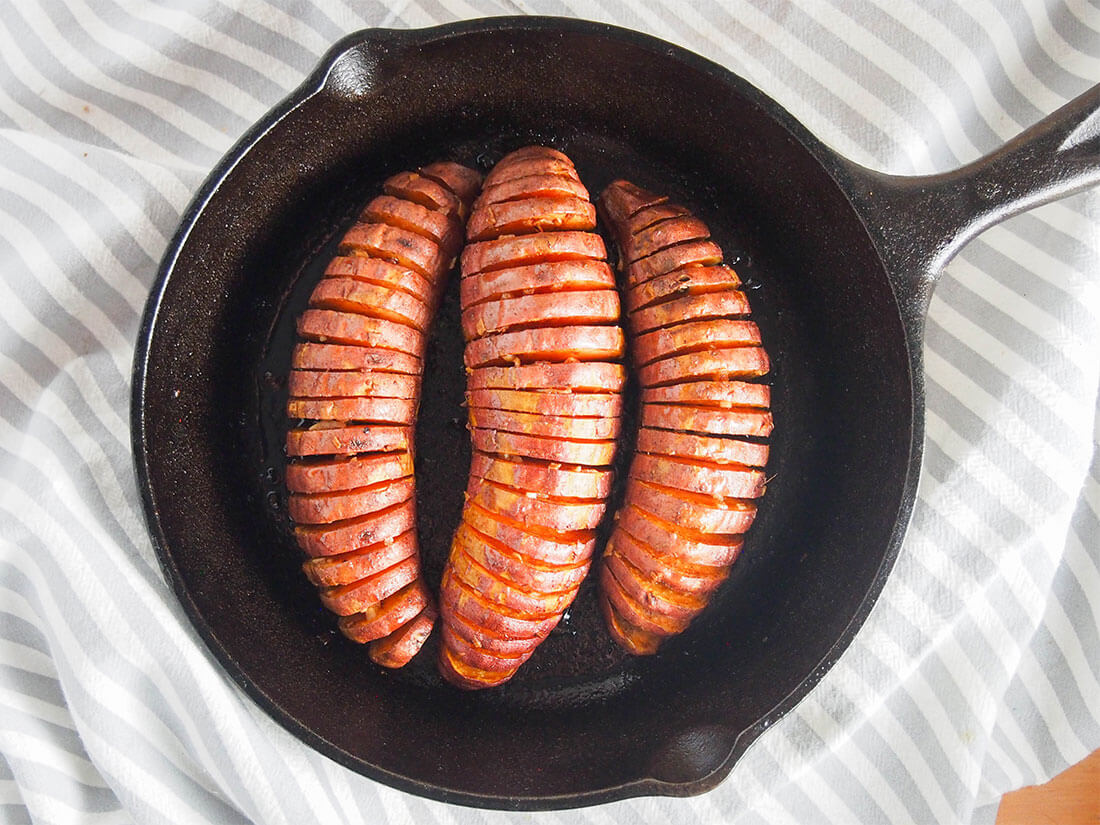 hasselback sweet potatoes in skillet from overhead