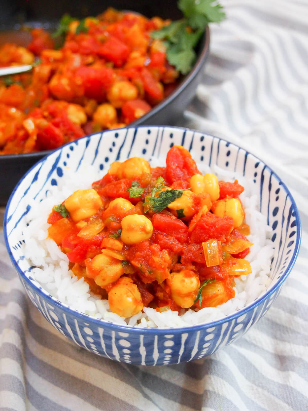 chana masala served over rice with rest in bowl behind