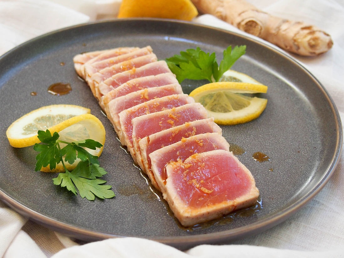 tuna tataki on plate with lemon and parsley as decoration