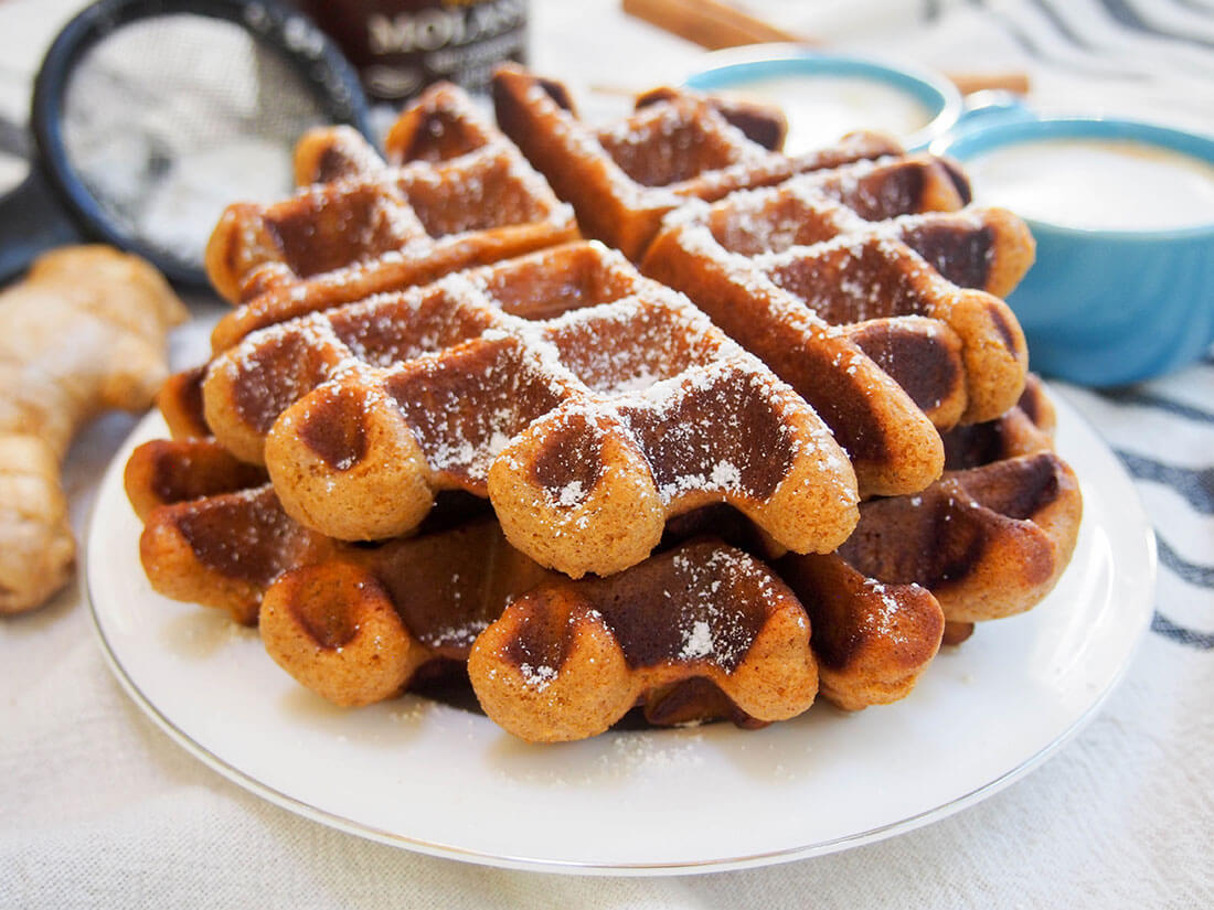 two gingerbread waffles stacked on top of each other on plate