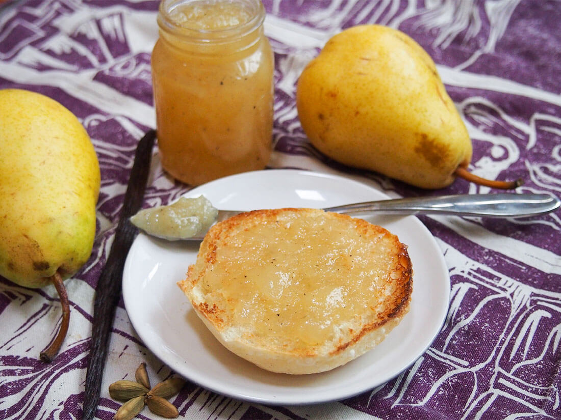 pear jam on piece of bread with jar behind
