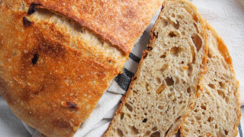sage and caramelized onion sourdough bread from overhead with two slices to side of loaf