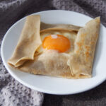 French buckwheat crepe filled with cheese ham and egg on plate