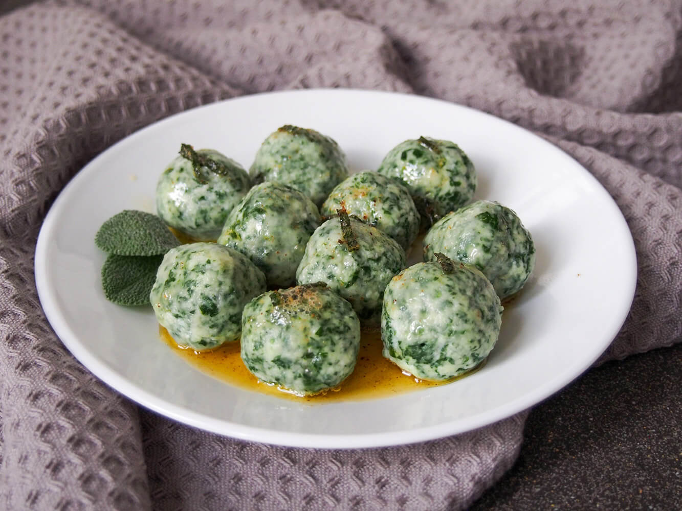 Ricotta and spinach gnudi on plate with sage browned butter