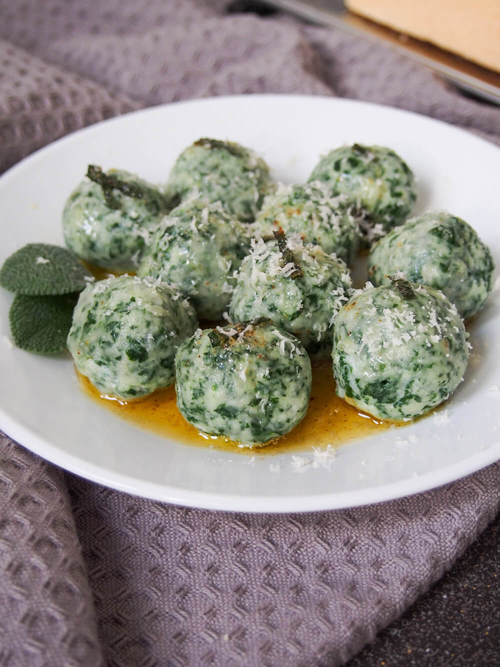 Ricotta and spinach gnudi on plate with parmesan on top