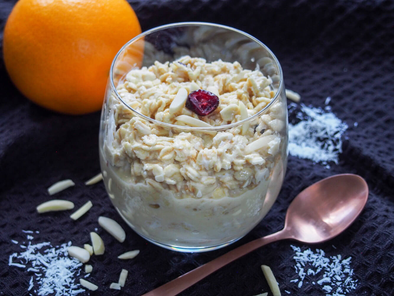 glass of orange overnight oats with spoon in front