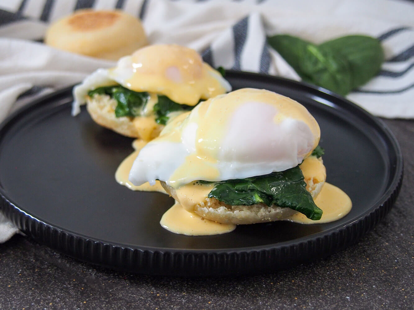 two stacks of eggs Florentine on black plate