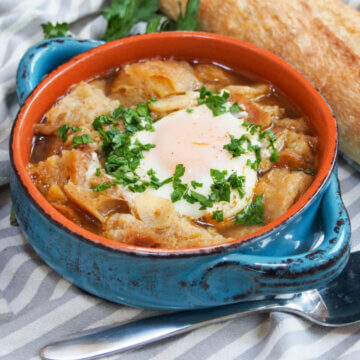 bowl of sopa de ajo Spanish garlic soup with spoon to side