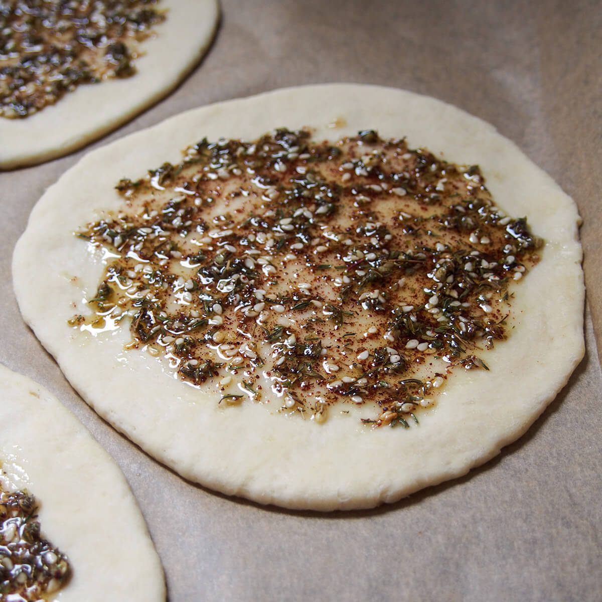 flatbread topped with za'atar mix ready to bake
