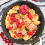 skillet with Kaiserschmarrn (Austrian torn pancakes) and sauce drizzled over