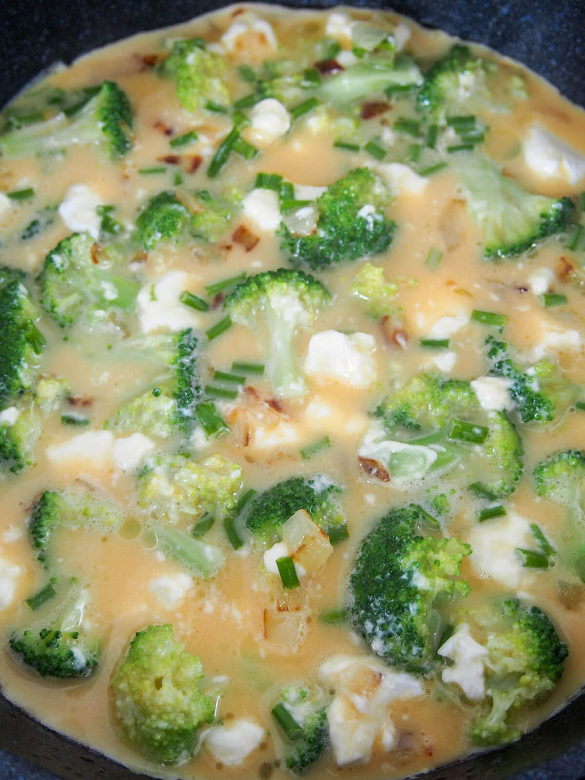 egg, broccoli and cheese mixture cooking in skillet
