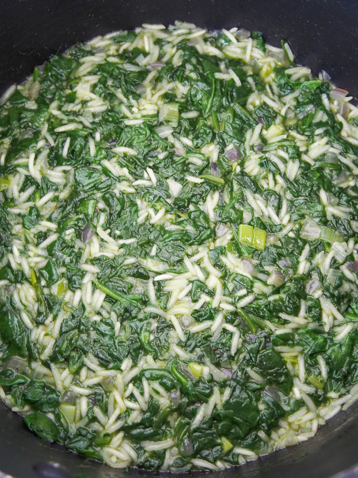 simmering spinach and rice mixture to cook rice and absorb liquid