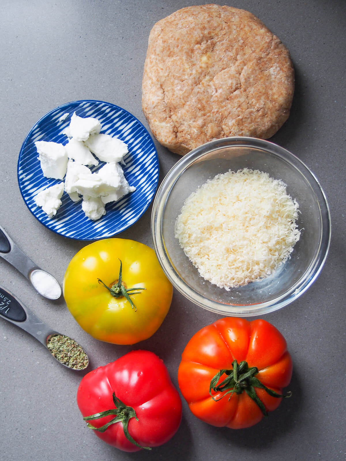 tomatoes, pastry dough, bowl with parmesan and dish with goat cheese