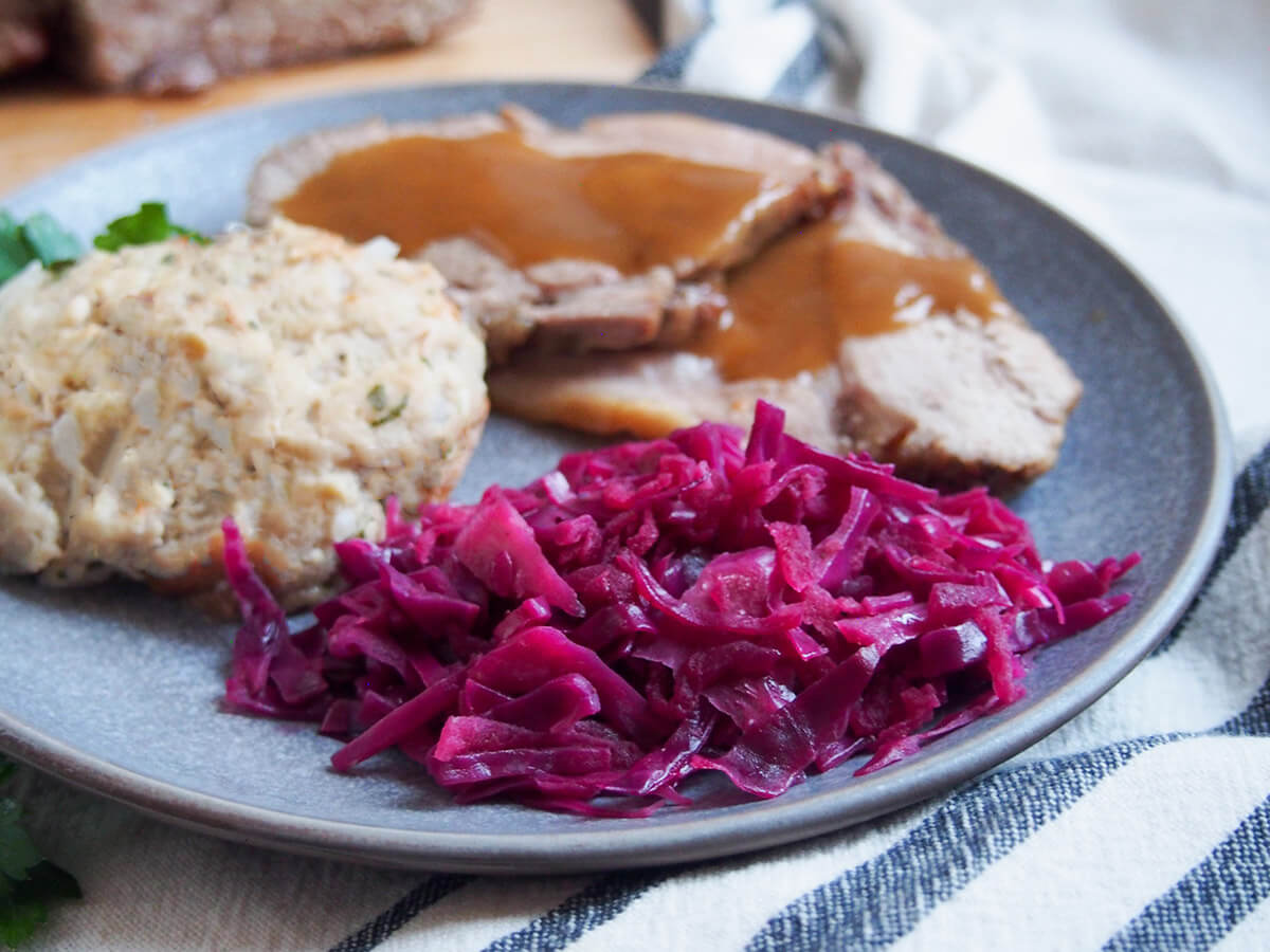 German braised red cabbage in front of pork with sauce and dumpling to side