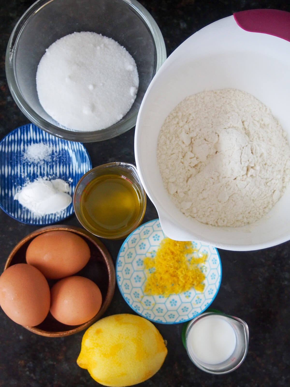 bowls with flour, sugar, eggs, oil, lemon zest