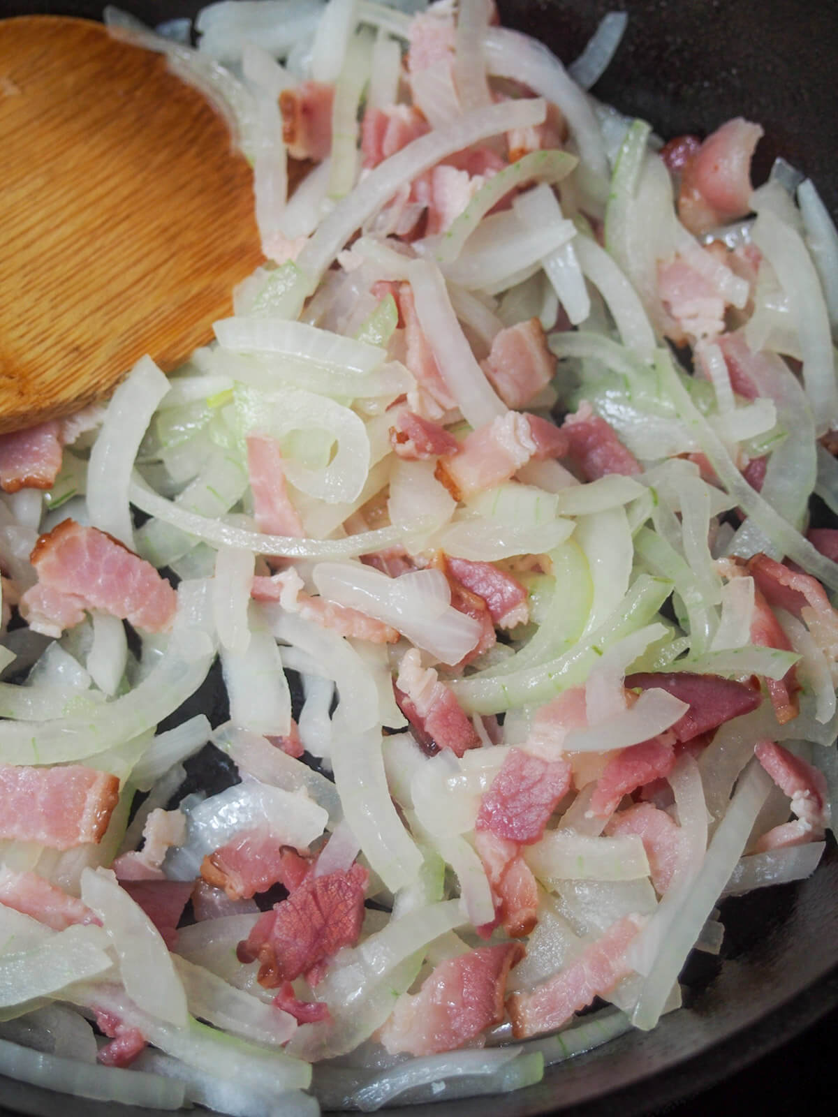 starting to cook onion and bacon in skillet