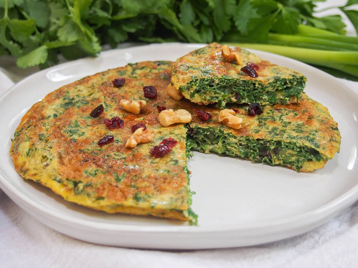 plate with kuku sabzi Persian herb frittata with slice on top of rest