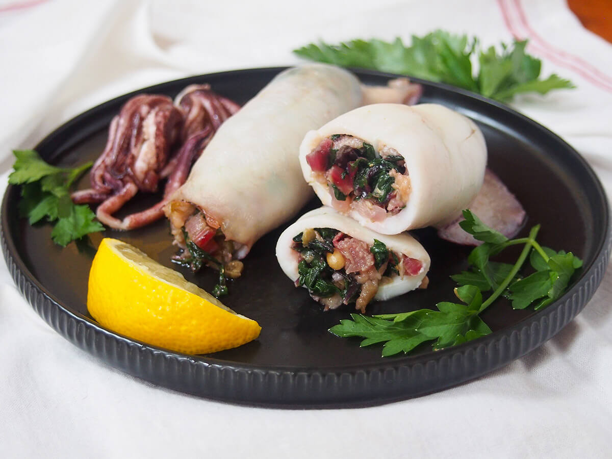 plate of Sicilian style stuffed squid with lemon slice and parsley garnishes
