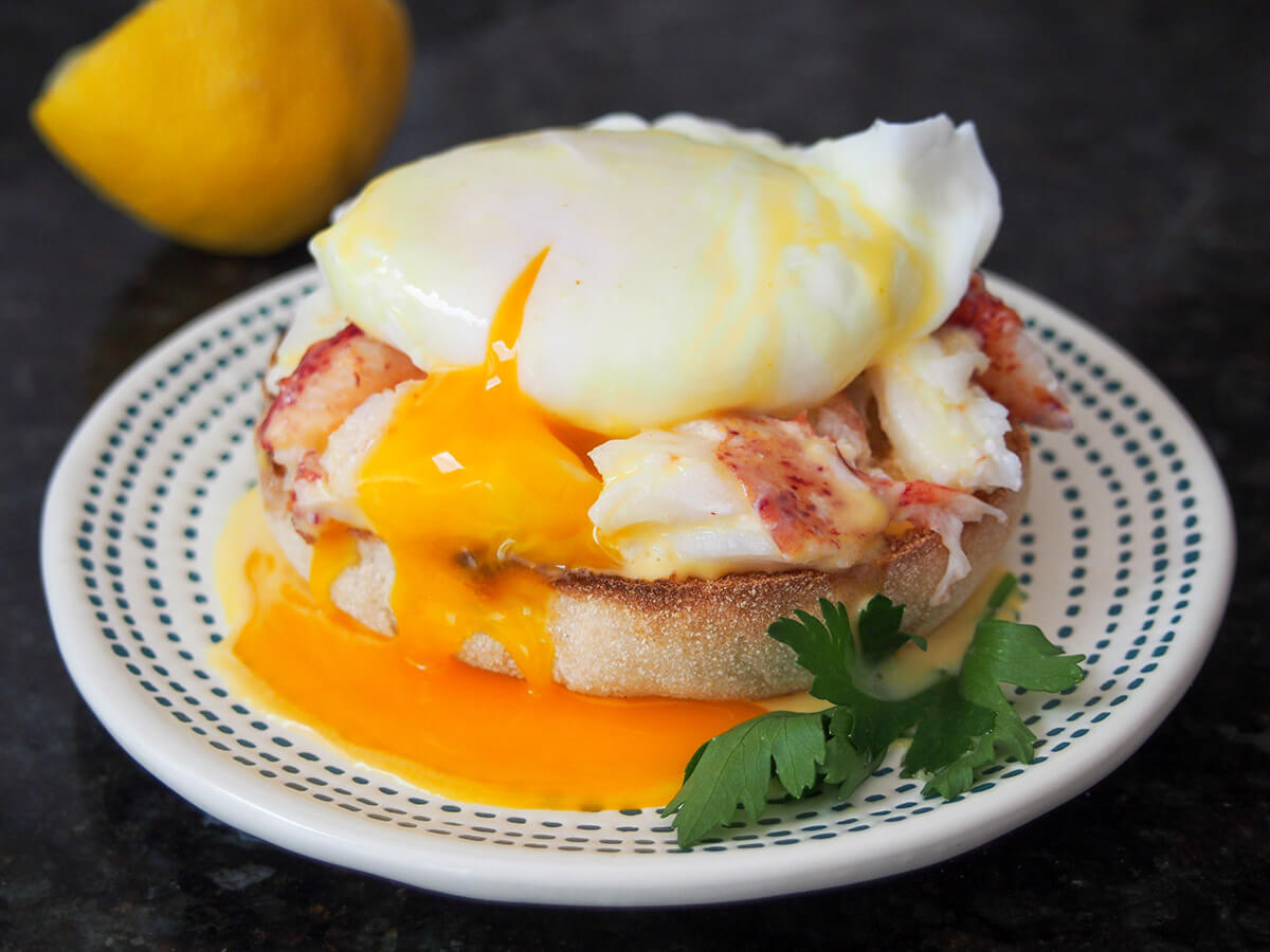 lobster eggs Benedict on plate with yolk running into sauce