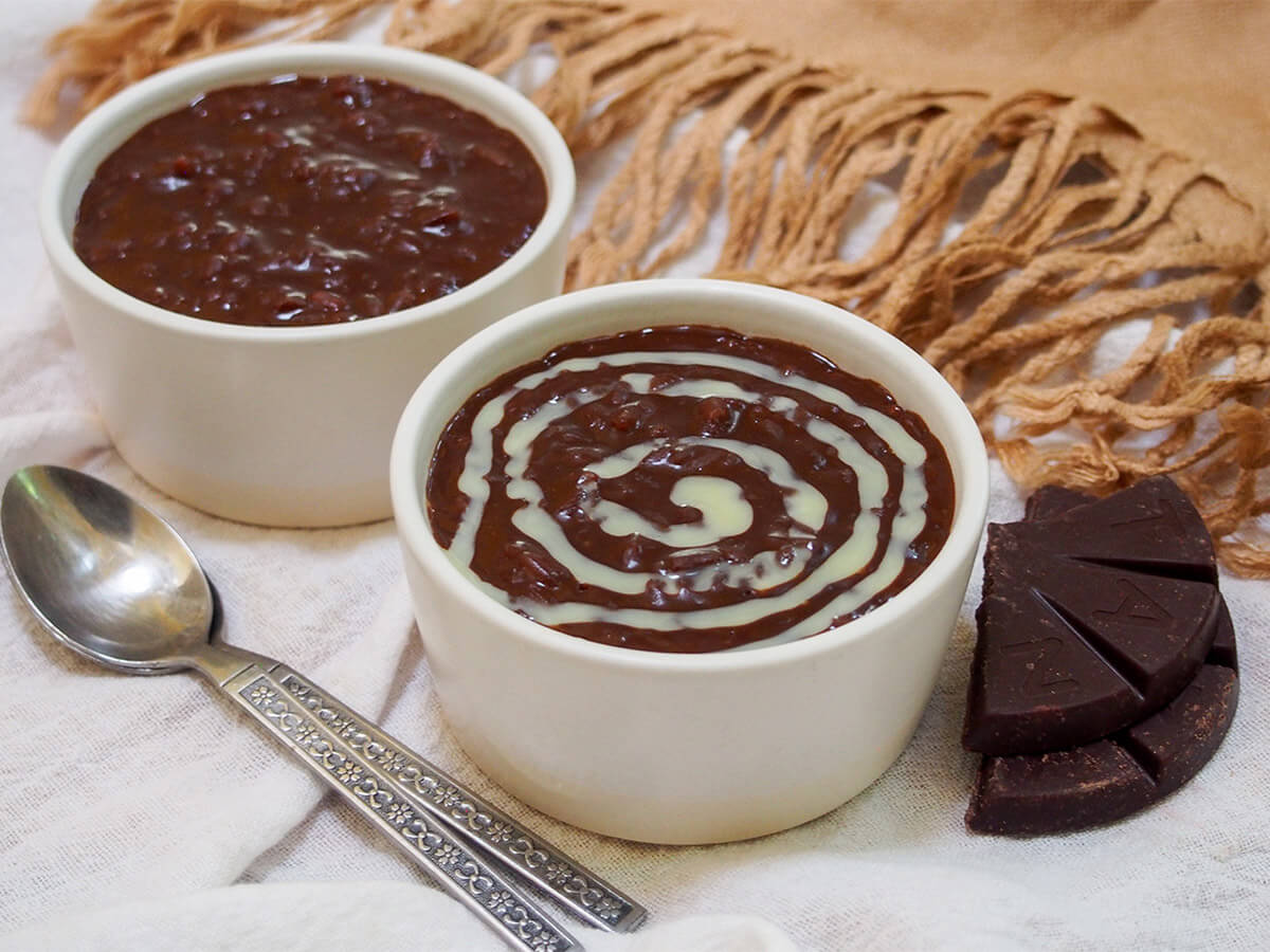 two dishes of champorado with spoons to side