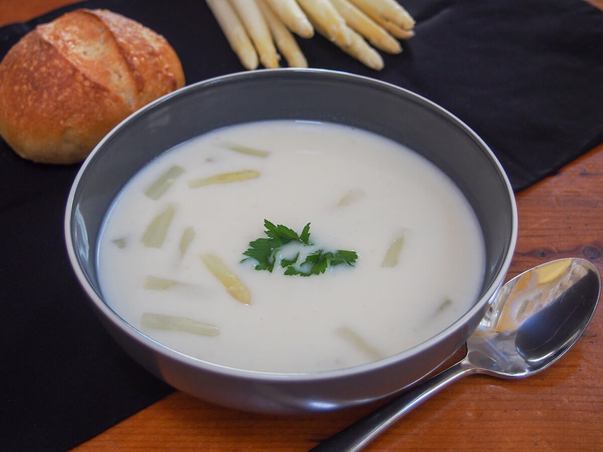bowl of white asparagus soup with spoon to side