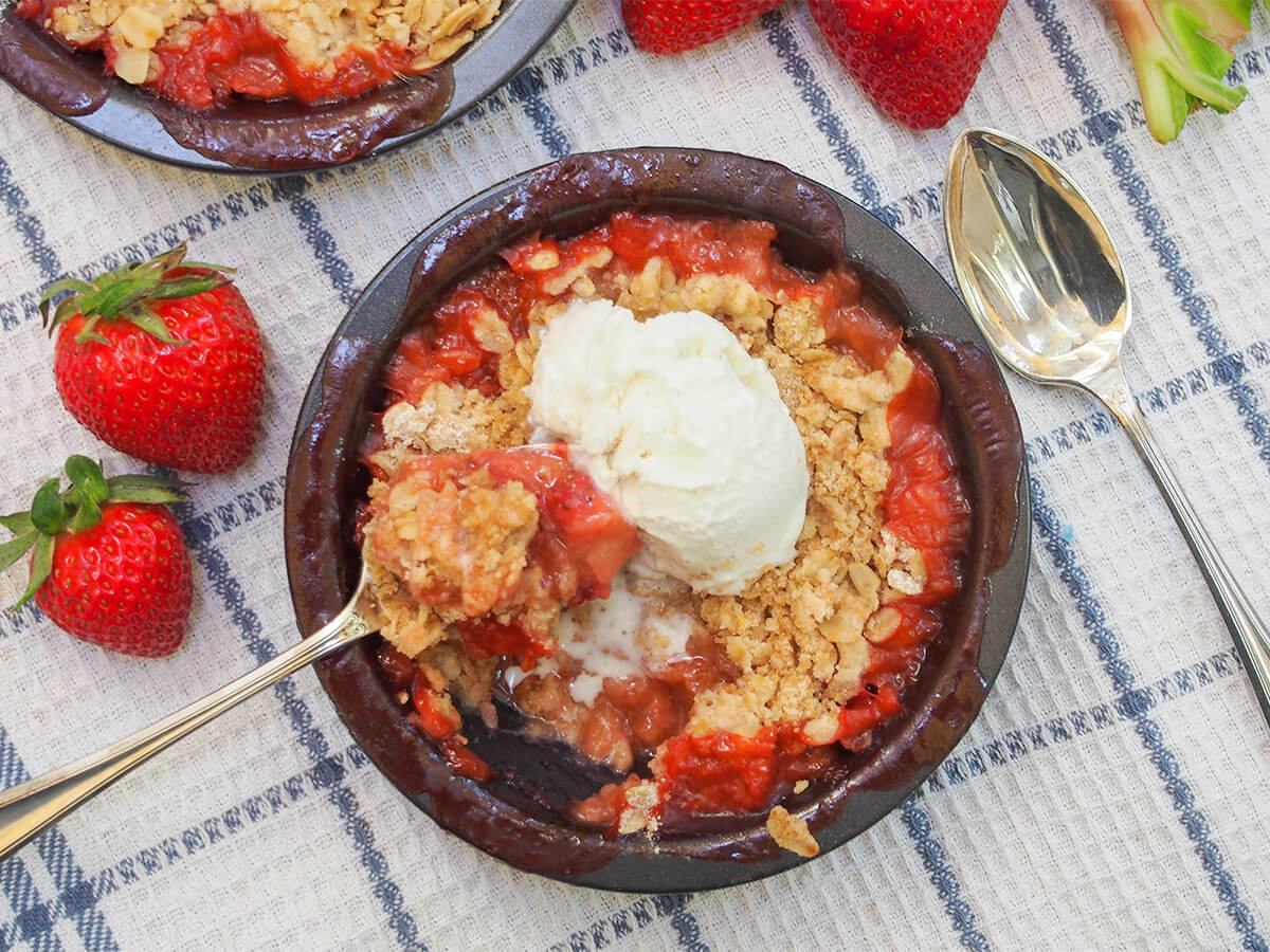 strawberry rhubarb crisp with spoon in dish and spoon to side