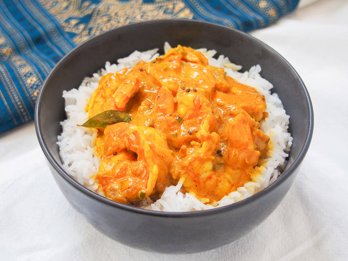 bowl of Malabar prawn curry shrimp with blue and gold cloth behind