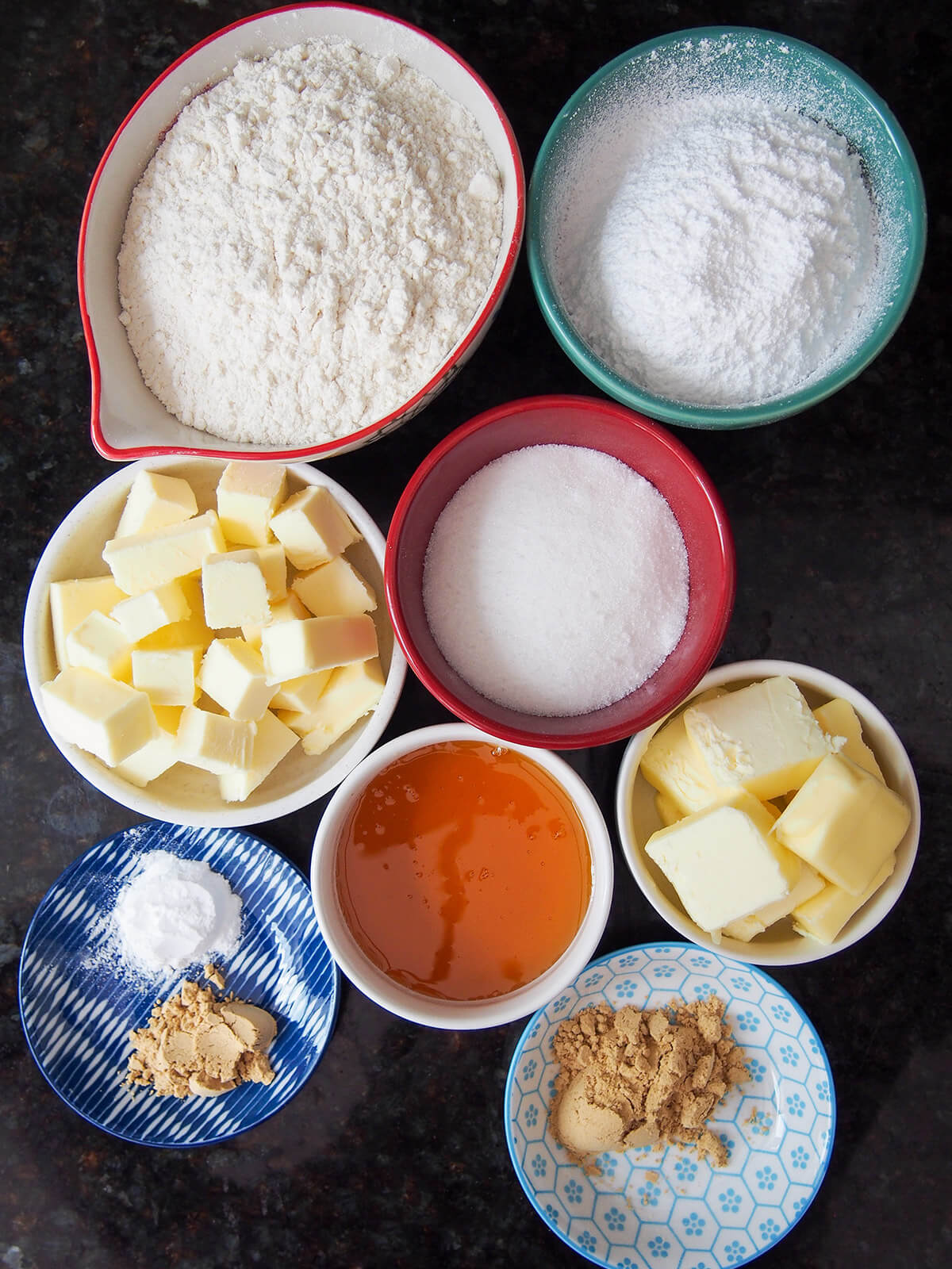 miski mąki, masła, cukru, imbiru i złotego syropu