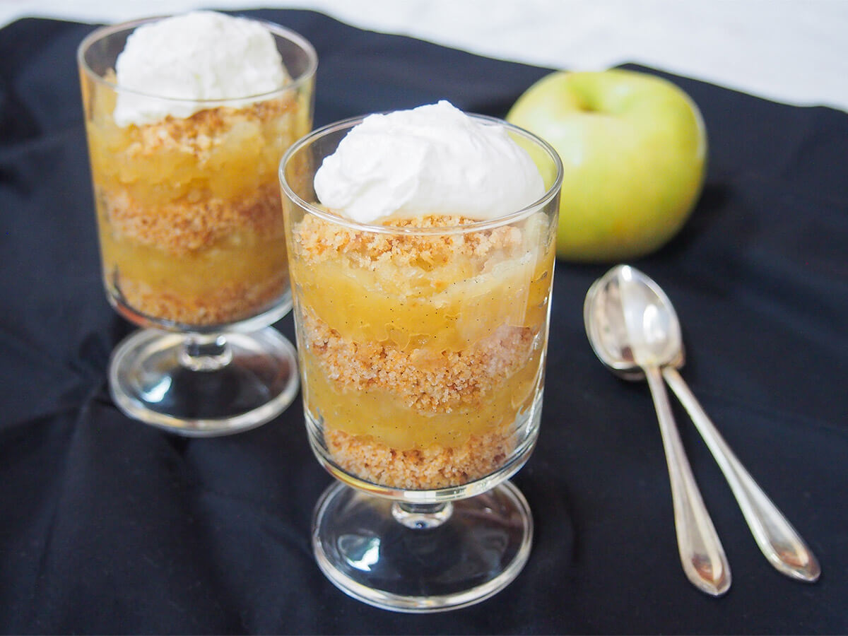 two glasses of æblekage Danish apple trifle with spoons to side