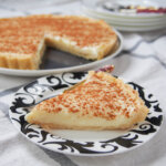 slice of milk tart (melktert) in front of rest of tart.