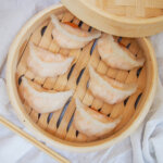 overhead view of har gow dumplings in bamboo steamer.