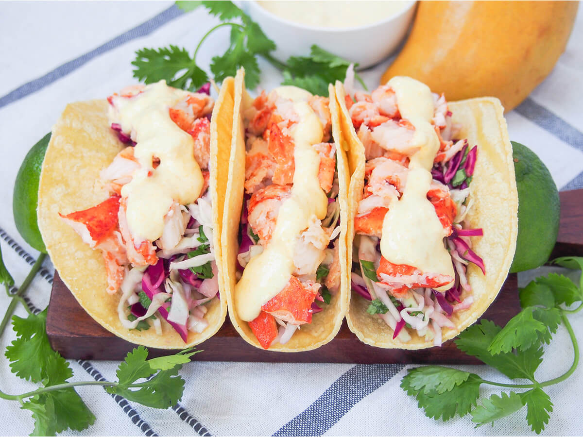 three lobster tacos in a row on board.