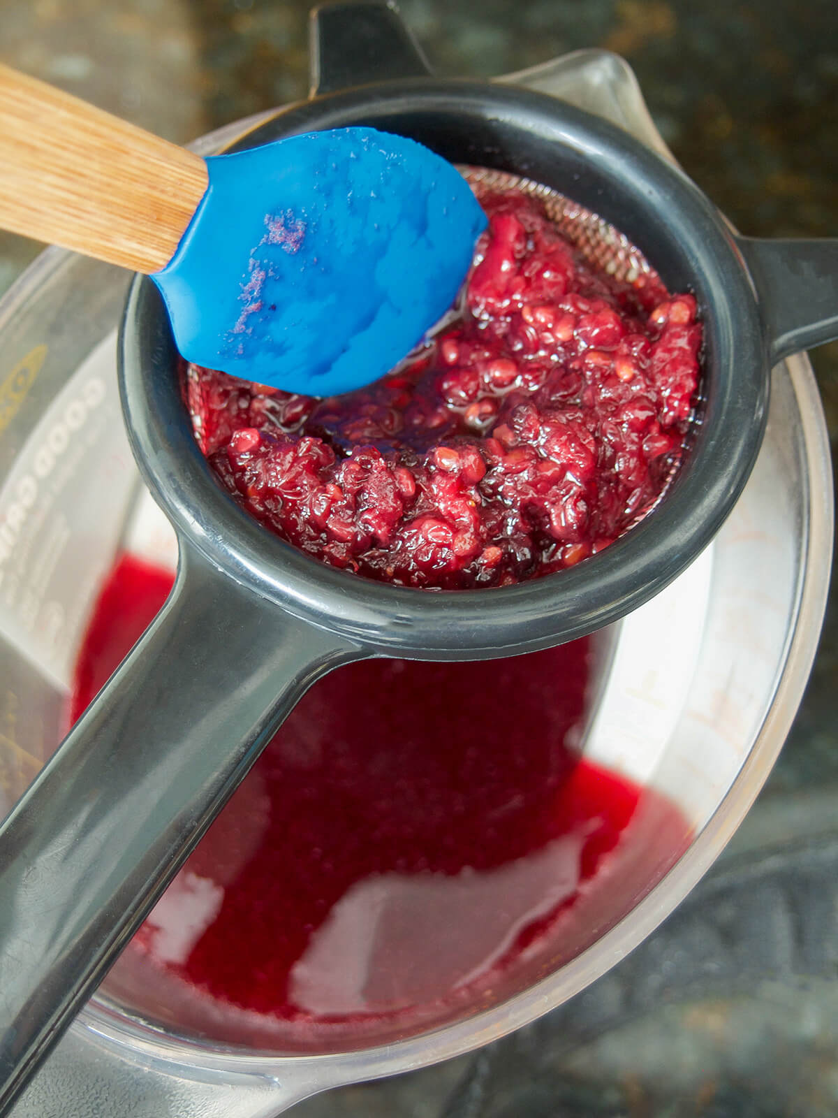 straining blackberry simple syrup straining blackberry solids from blackberry simple syrup.