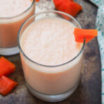 close view of glass of papaya milkshake.
