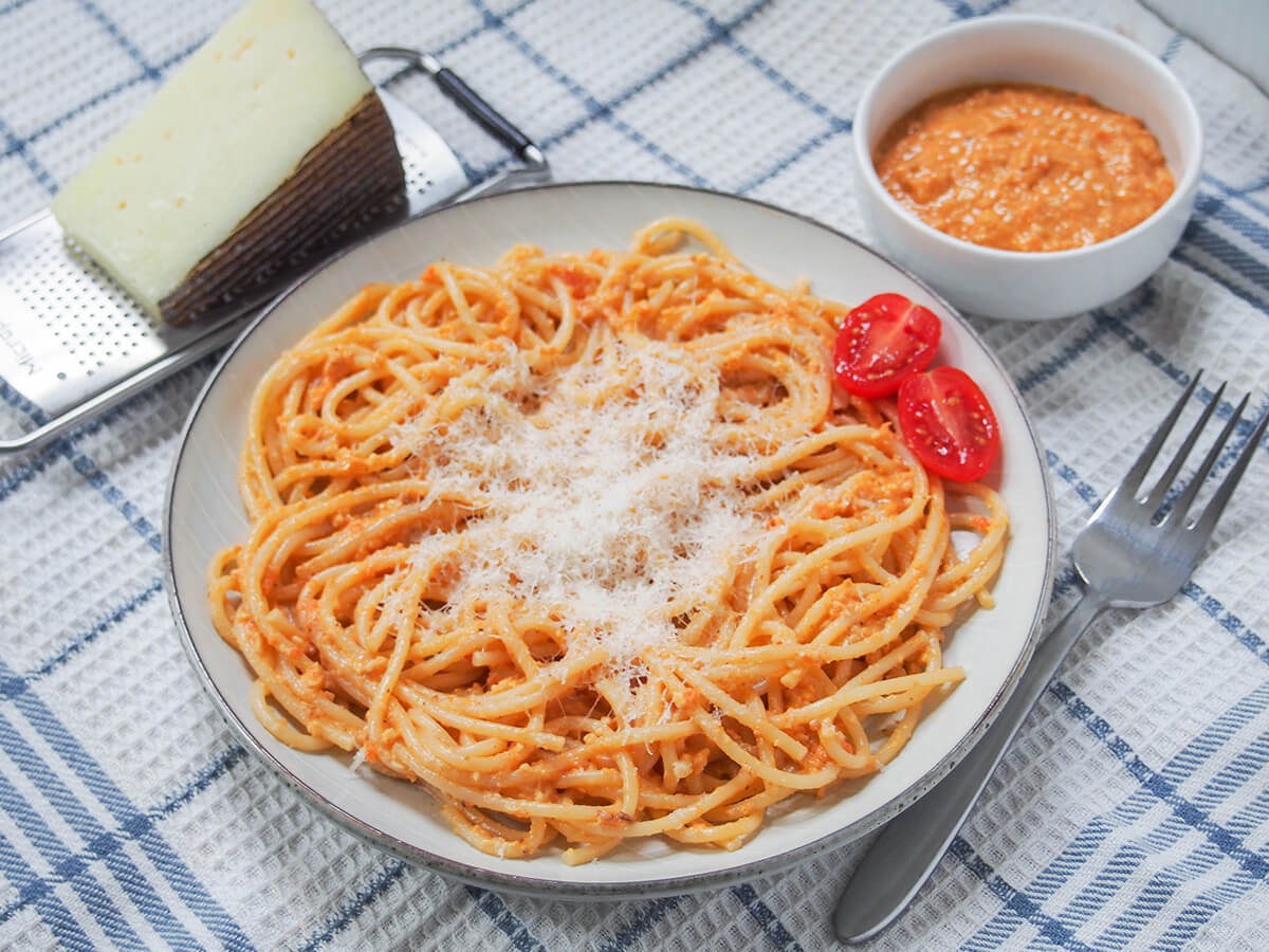 plate of romesco pasta side view of plate of romesco pasta with fork to right of plate.