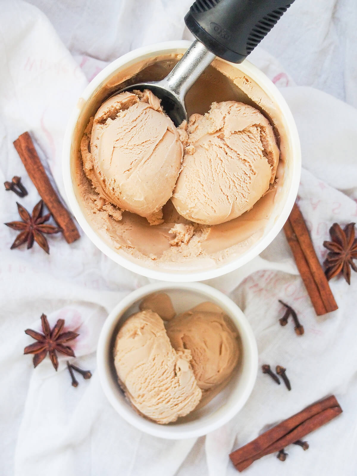 overhead view of tub of chai ice cream with scoop in it and small dish with some below.