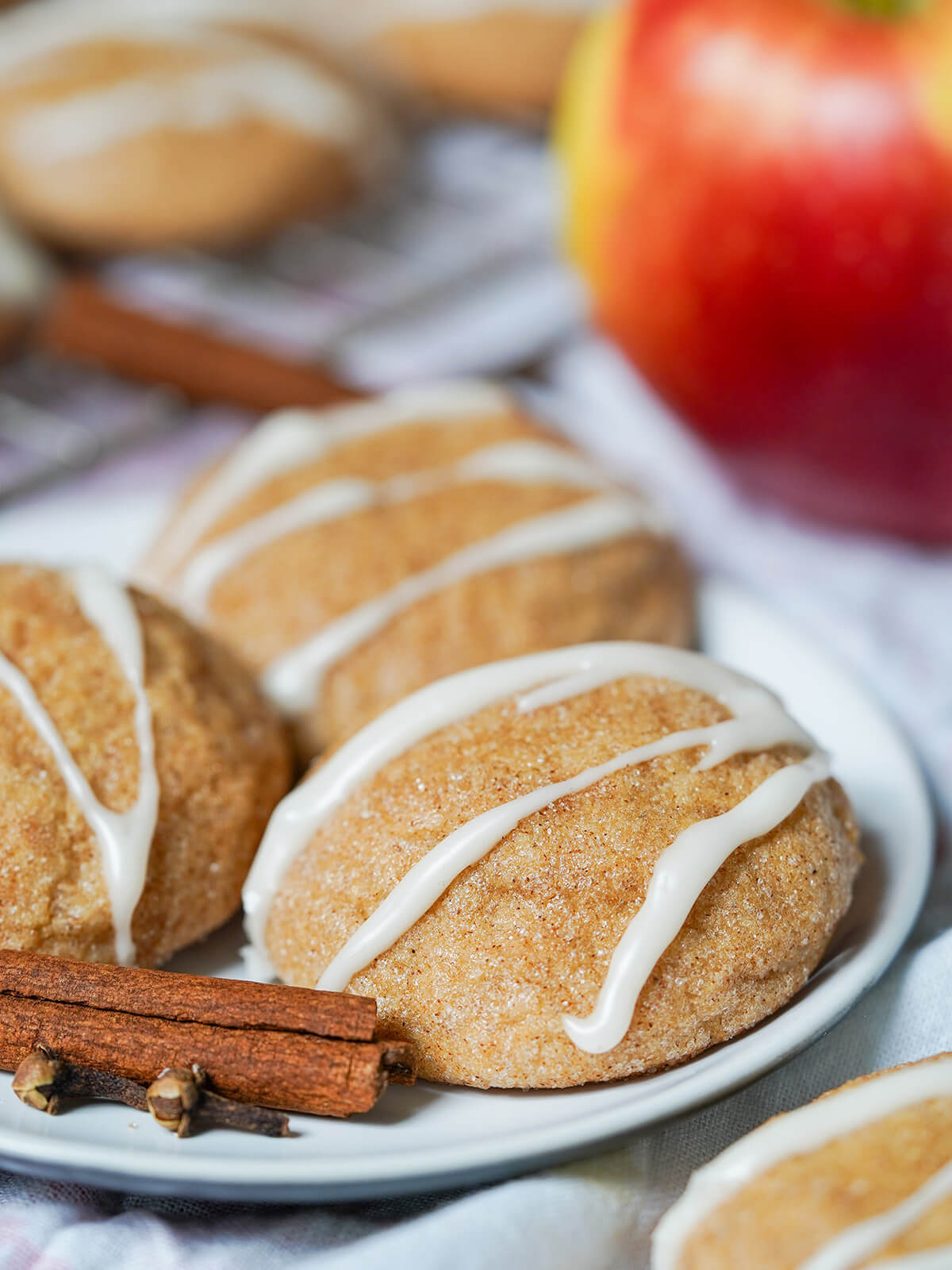close up of an apple cider cookie showing cinnamon sugar on outside and icing drizzled on top.