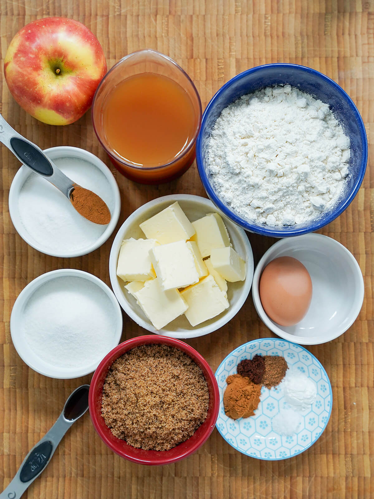 apple cider cookies ingredients overhead view of bowls of flour, butter, sugars, spices, egg and measure of apple cider.