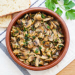 terracotta dish of Spanish garlic mushrooms, champiñones al ajillo.