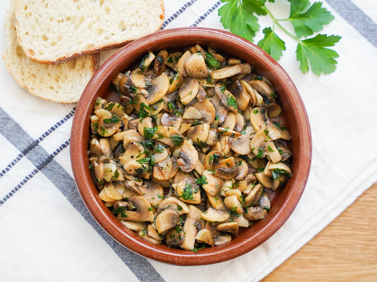 plate of Spanish garlic mushrooms, champiñones al ajillo, from overhead.