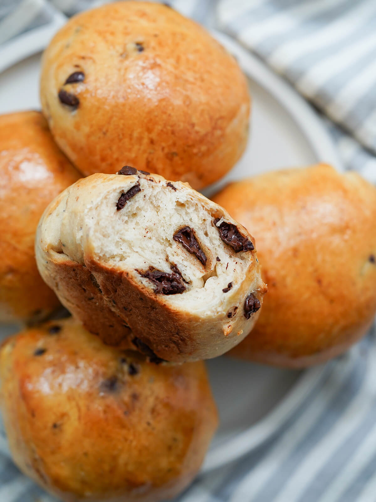 Norwegian chocolate buns, sjokoladeboller with one on top cut into showing melty chunks of chocolate.