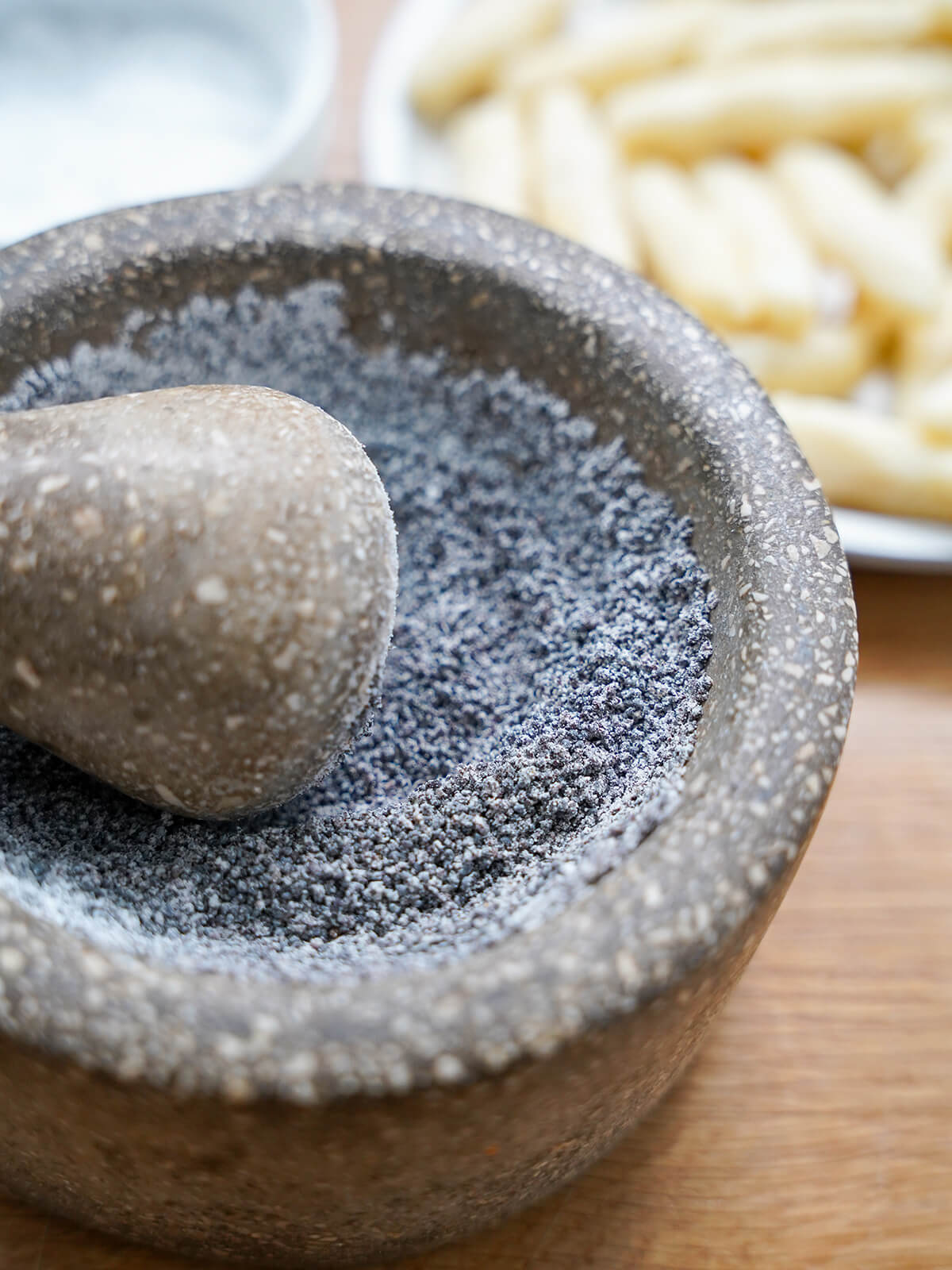 grinding poppy seeds and powder sugar together with pestle and mortar.