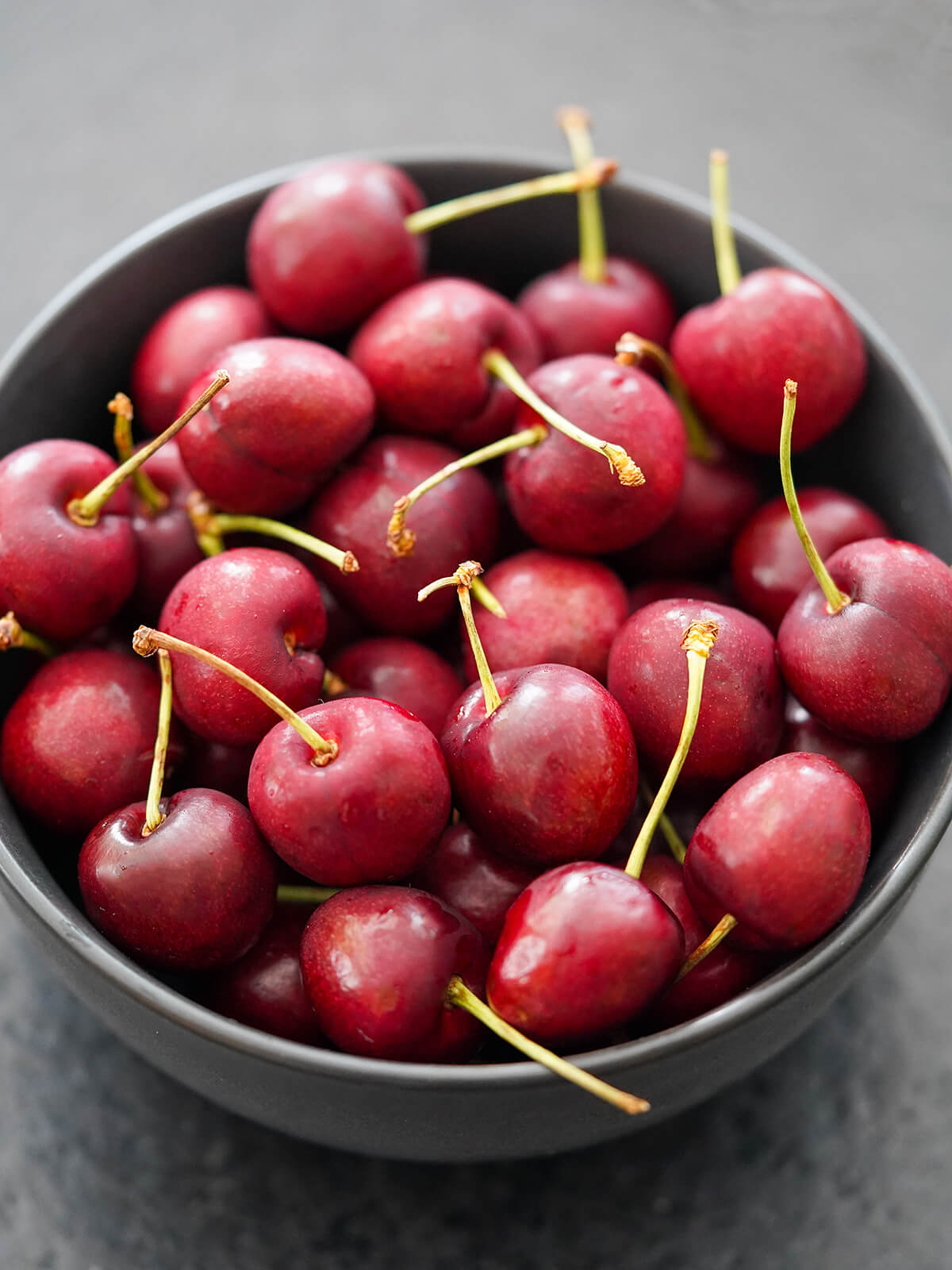 cherries for cherry compote bowl of cherries in grey bowl.